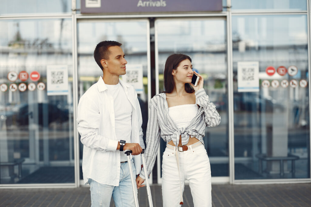 Couple in a airport. Beautiful brunette in a white shirt. Man in a white t-shirt