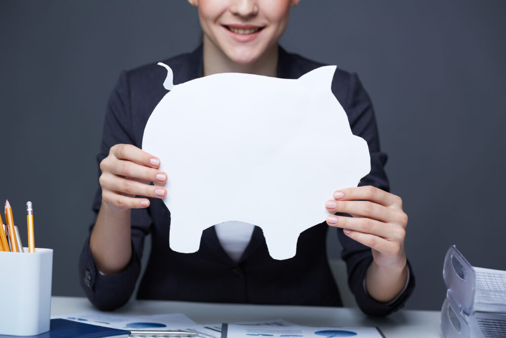 Hands of businesswoman holding paper piggy